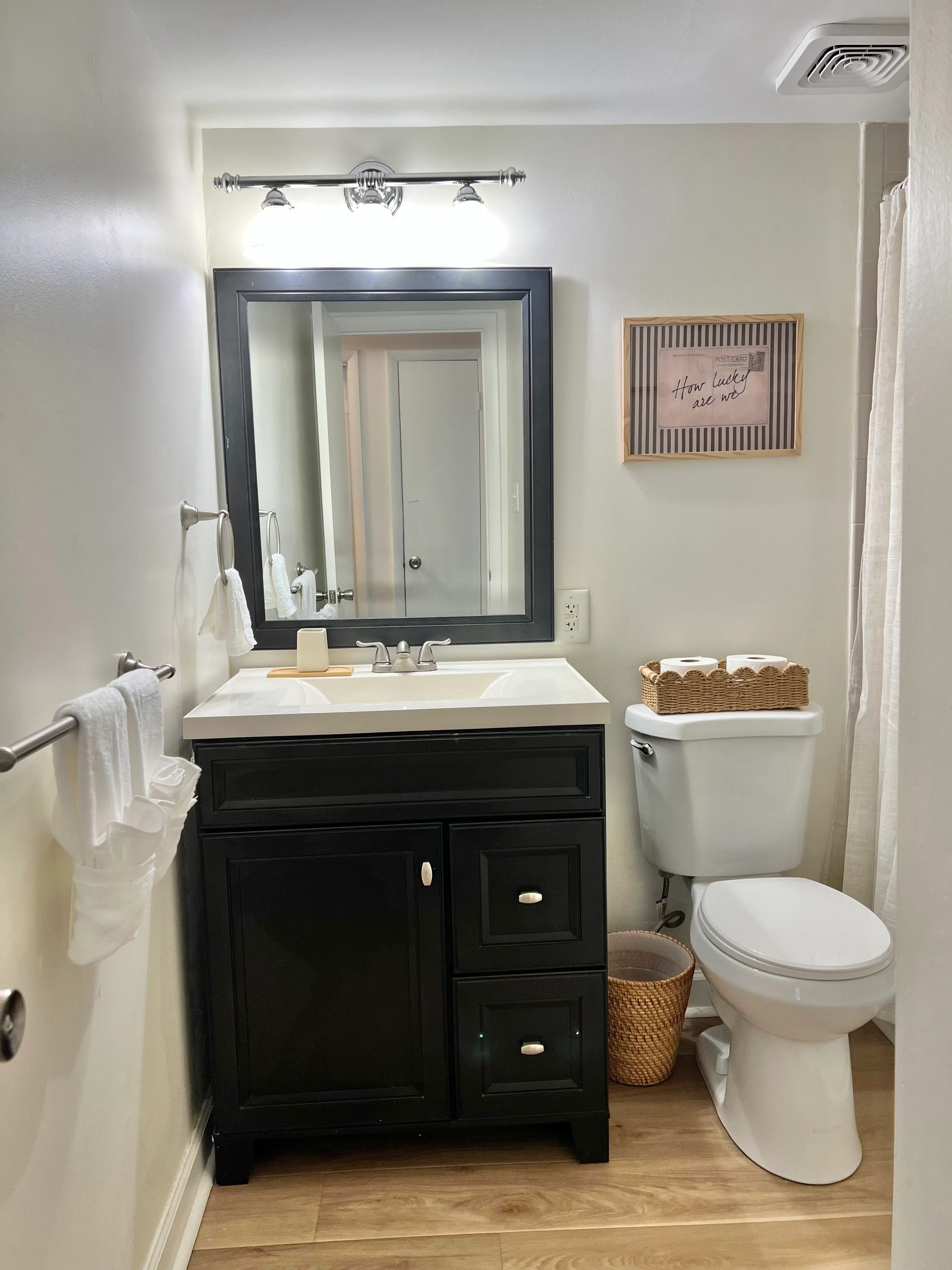 Bathroom with a black vanity, framed mirror, and fresh white towels